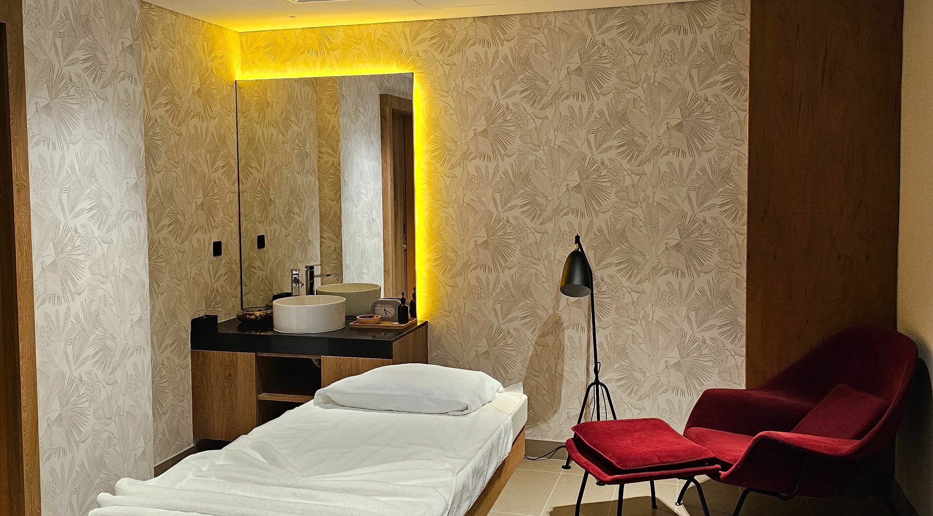 Versailles Spa - Aloft Airport Hotel massage room in Dubai featuring a cozy bed and calming decor.