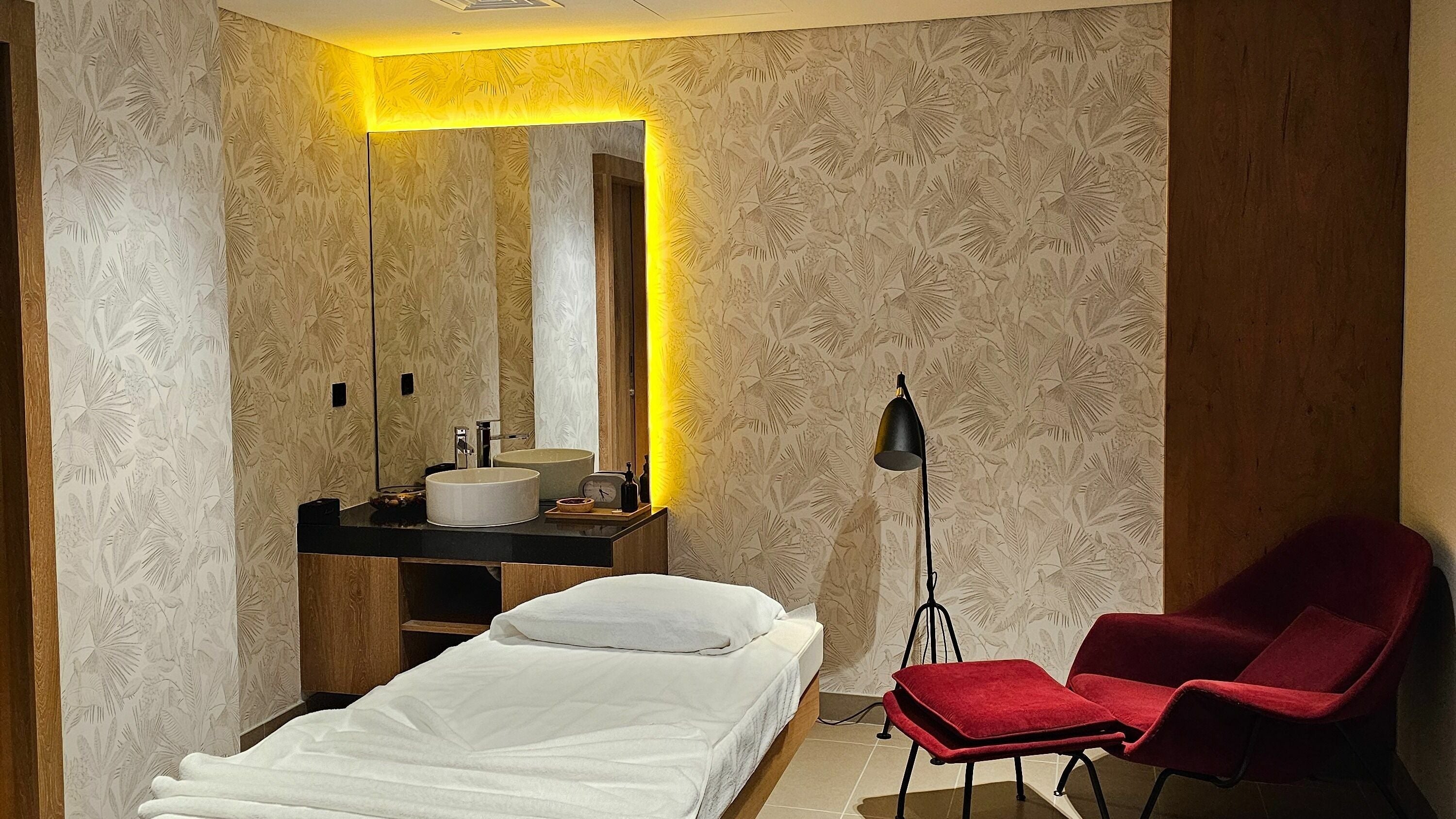 Versailles Spa - Aloft Airport Hotel massage room in Dubai featuring a cozy bed and calming decor.