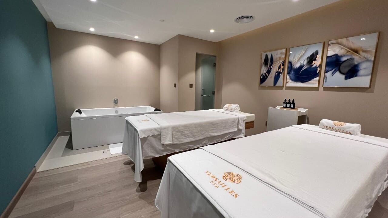 Relaxing massage room at PINE Spa by Versailles in Dubai, AE featuring white treatment tables and elegant decor.