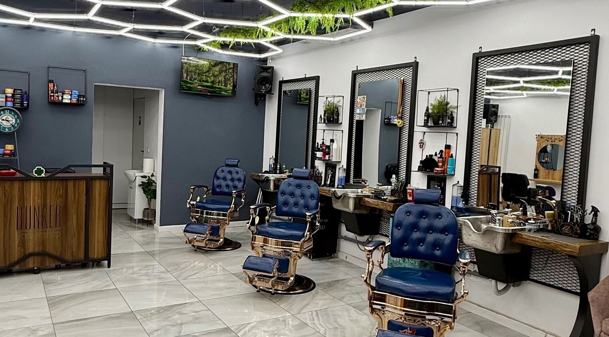 Interior modern al Bunker Barbershop & Salon din Iași, Județul Iași, RO, cu scaune elegante și decor urban.