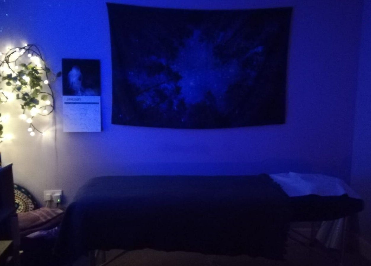 Relaxing treatment room at Violet Moon, Westcroft, England, GB, adorned with soft lighting and calming decor.