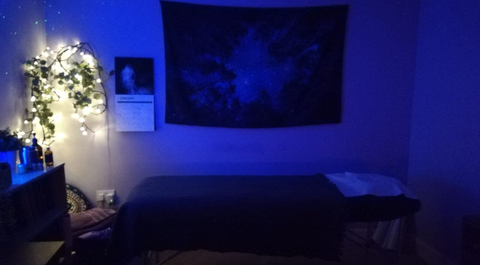 Relaxing treatment room at Violet Moon, Westcroft, England, GB, adorned with soft lighting and calming decor.