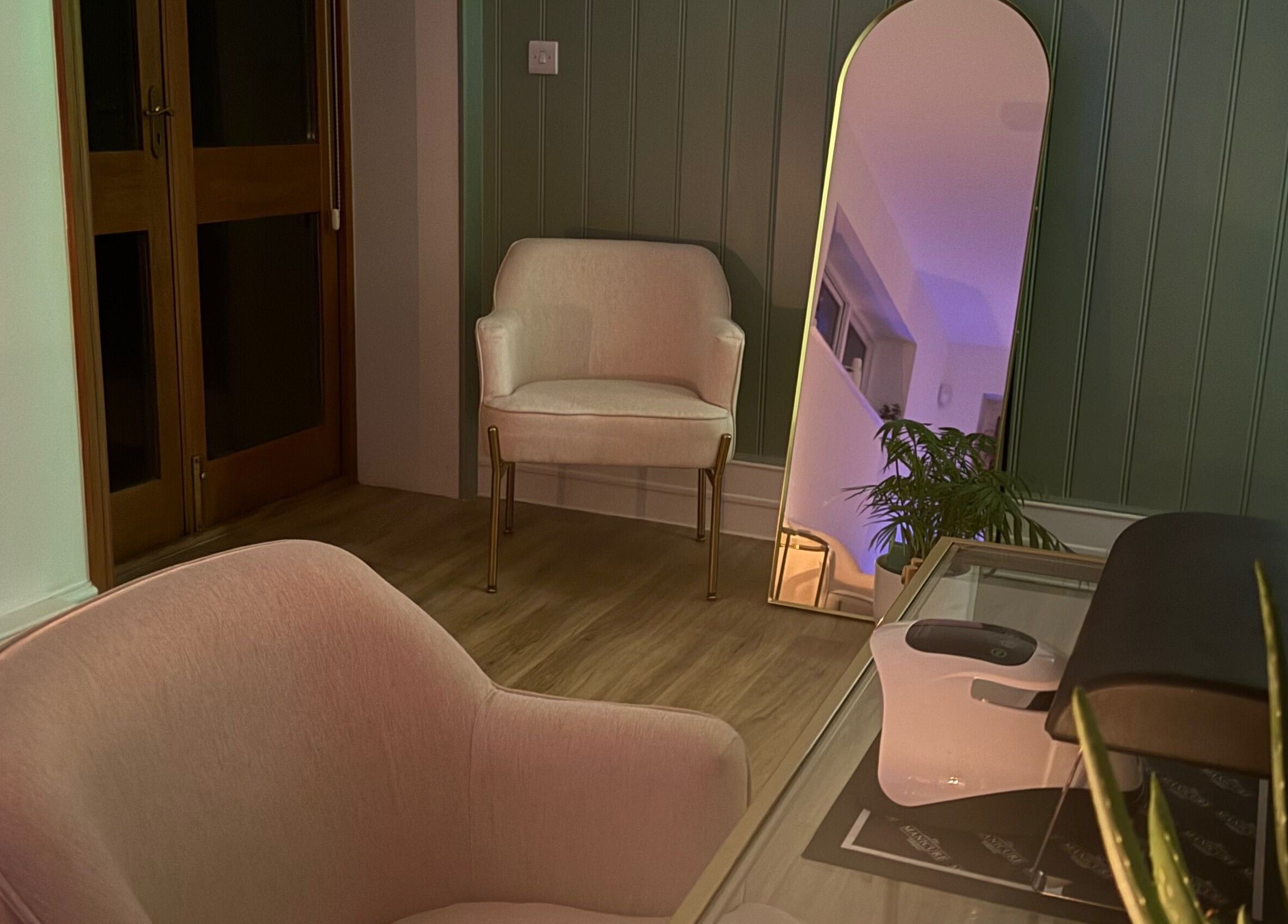 Cozy seating area at Beauty by Elliemai, Rowlands Castle, England, GB with modern chairs and mirror.