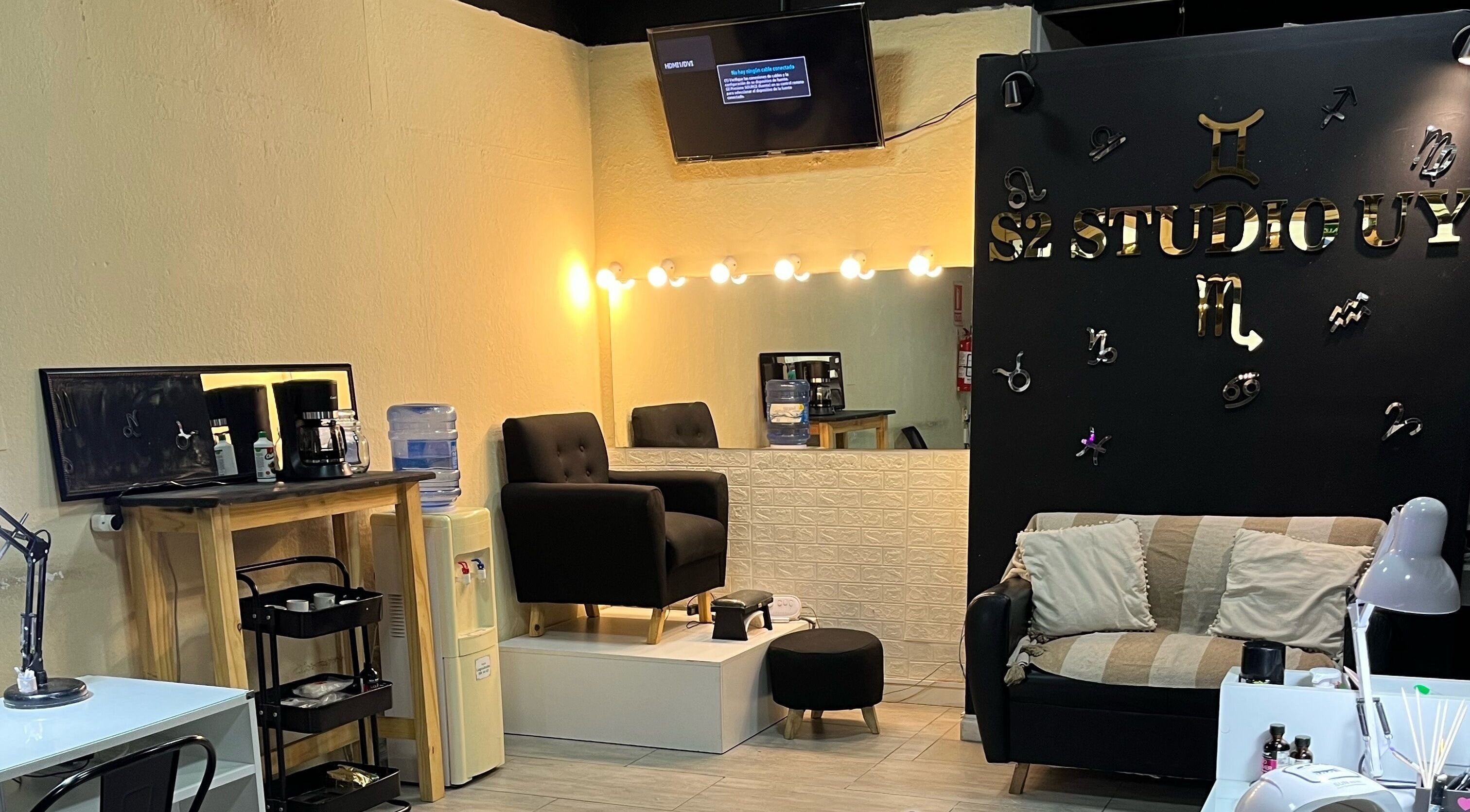 Espacio acogedor de S2Stefanie en Montevideo. Sofá negro y estación de café iluminada.