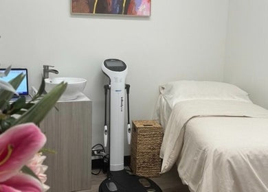 Elegant treatment room at OYA Wellness - Brickell, Miami, Florida, US with a cozy bed and fresh flowers.