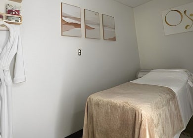 Tranquil massage room at OYA Wellness - Brickell, Miami, Florida, US with cozy decor and a spa robe.