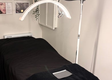 Salle de soin relaxante à Beauty By Martine, Saint-Constant, Québec, CA, avec table de traitement sombre.