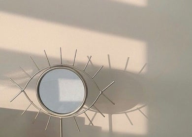 Miroir en forme d'œil au salon Beauty By Martine, Saint-Constant, Québec, CA, capturant une ambiance chaleureuse.