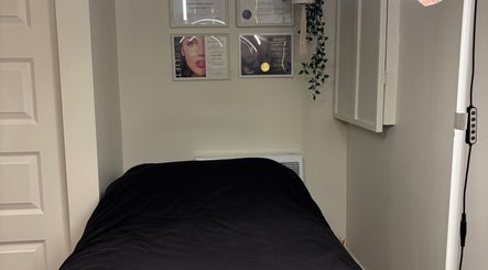 Salle de soins de Beauty By Martine à Saint-Constant, Québec, avec un lit de massage élégant.