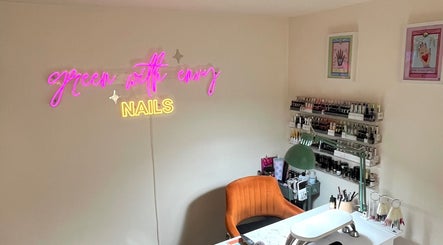 Interior of Green with Envy Nails in Sutton, South London, featuring a neon sign and nail polish display.