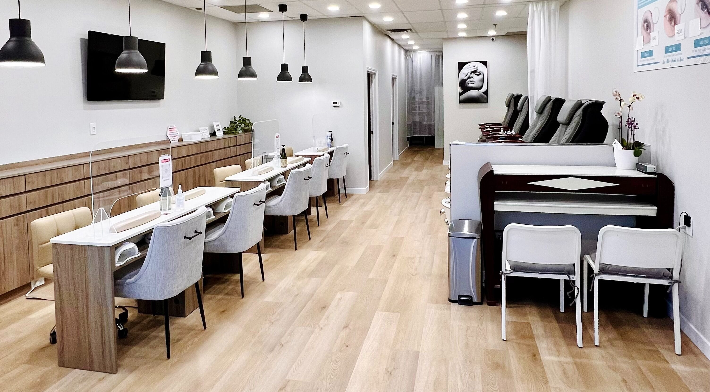 Modern nail salon interior at Au Delà Beauty Spa, Newmarket, Ontario featuring stylish seating and chic decor.
