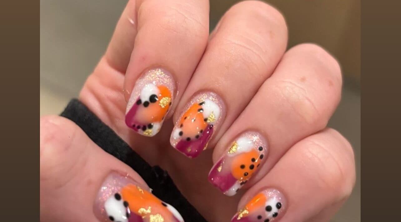 Vibrant nail art with orange and purple at R and R Tranquility, Aberdeen, Scotland, GB.