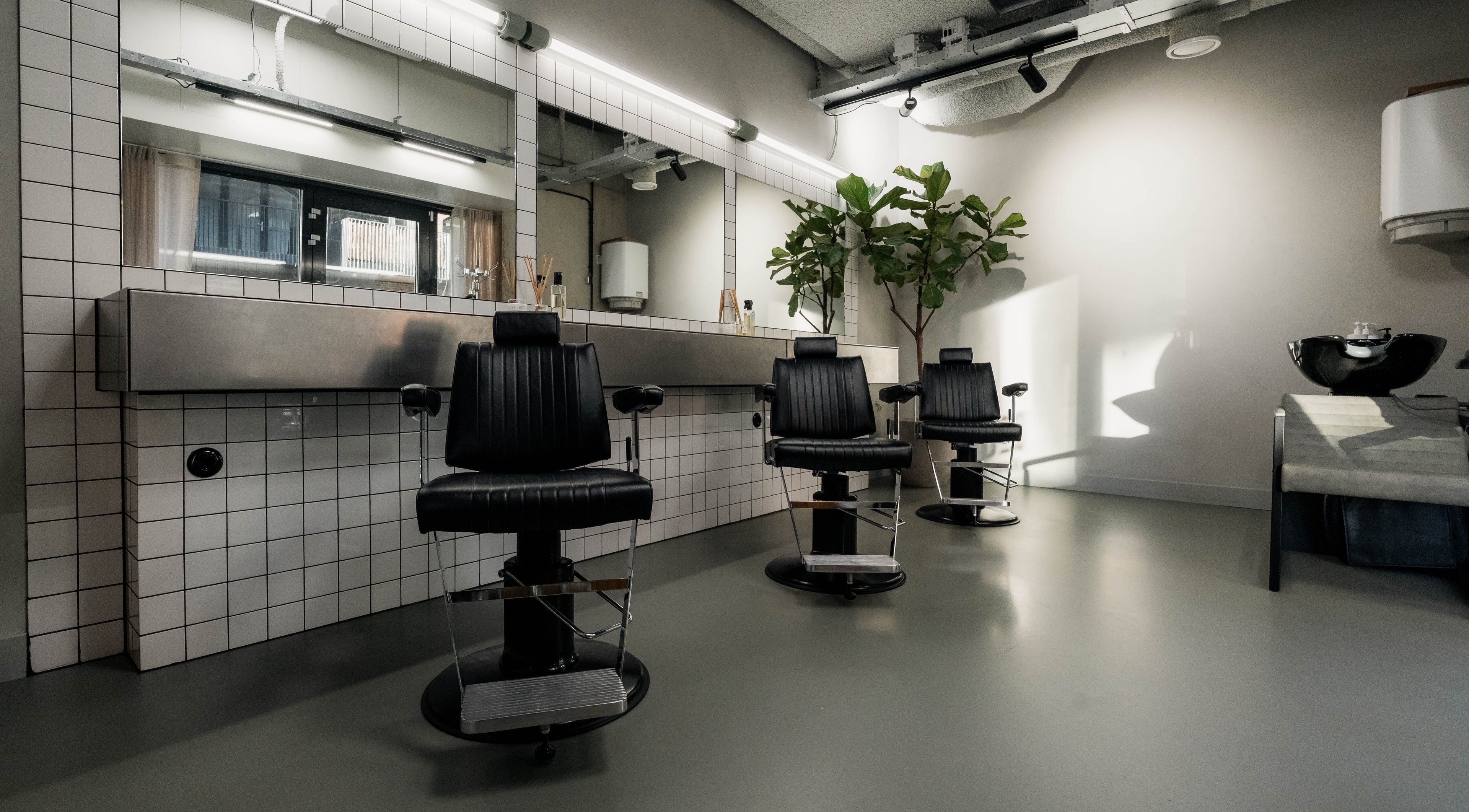 Moderne barbershop met zwarte stoelen bij DOQ Barbers - Rijnkanaalkade 55, Amsterdam, Noord-Holland, NL.