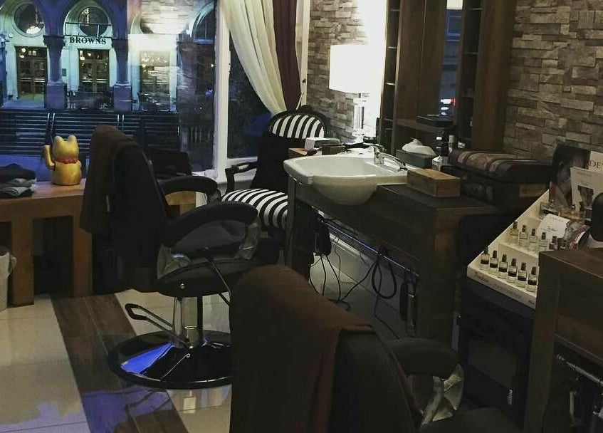 Cozy interior of Berkeley Barbers in Bristol, England, GB, showcasing stylish barber chairs and ambient lighting.