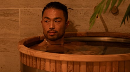 Relaxing soak at Studio Sweat in Auckland, NZ. Enjoy rejuvenation in a serene wooden tub environment.