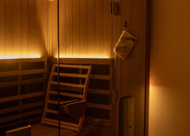 Cozy wooden sauna at Studio Sweat in Auckland, NZ, featuring ambient lighting for relaxation.