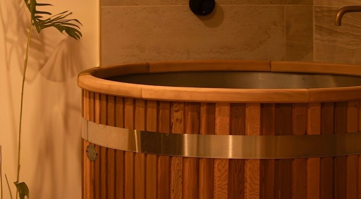 Wooden spa tub at Studio Sweat in Auckland, Auckland, NZ with plant nearby.