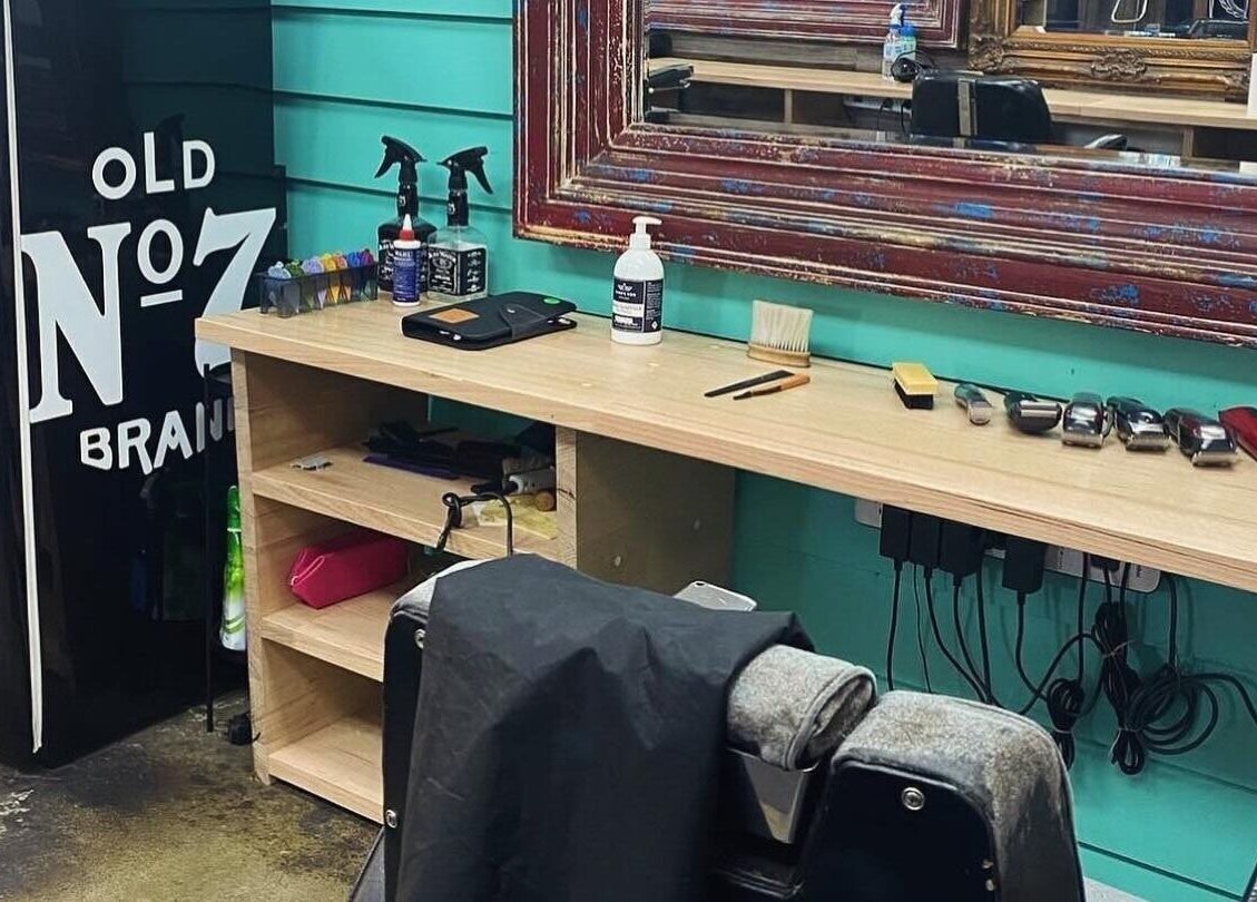 The Alley Barber Frankston, VIC, AU: Vintage barber chair and grooming tools next to a classic mirror.