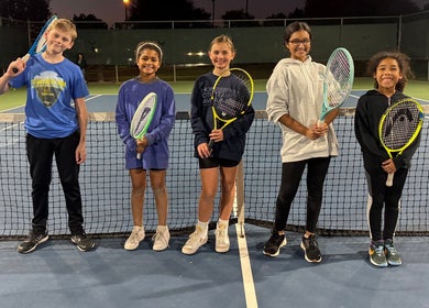 Kids enjoying tennis at Racket & Paddle Club, Gilbert, Arizona, US, standing on court with racquets.