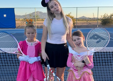 Children in princess costumes with tennis rackets at Racket & Paddle Club, Gilbert, Arizona, US.