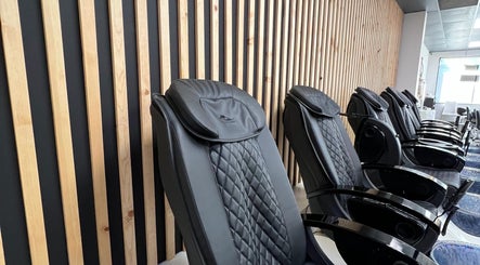Sleek massage chairs at Gloss Spa, Lenexa, Kansas, US, offering ultimate relaxation in a modern setting.