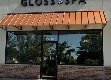 Entrance of Gloss Spa in Lenexa, Kansas, US featuring a modern facade with large glass windows.