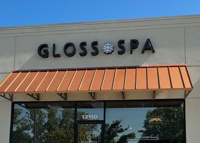Front entrance of Gloss Spa in Lenexa, Kansas, US with modern signage and awning.