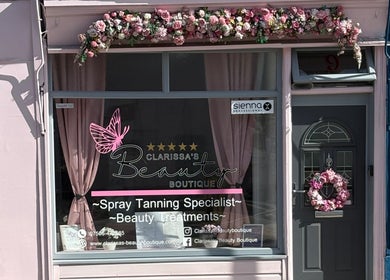 Exterior of Clarissa's Beauty Boutique in March, England, GB adorned with floral decorations.