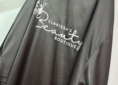 Salon cape with logo at Clarissa's Beauty Boutique, March, England, GB.
