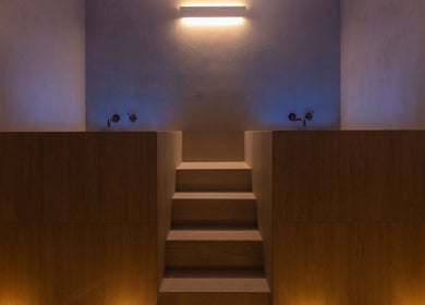 Relaxing dimly lit spa room at My Recovery Lounge, Port Melbourne Beach, Victoria, AU with wooden steps and wall lights.