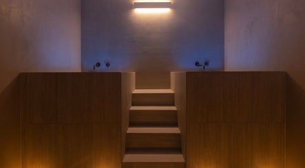 Relaxing dimly lit spa room at My Recovery Lounge, Port Melbourne Beach, Victoria, AU with wooden steps and wall lights.