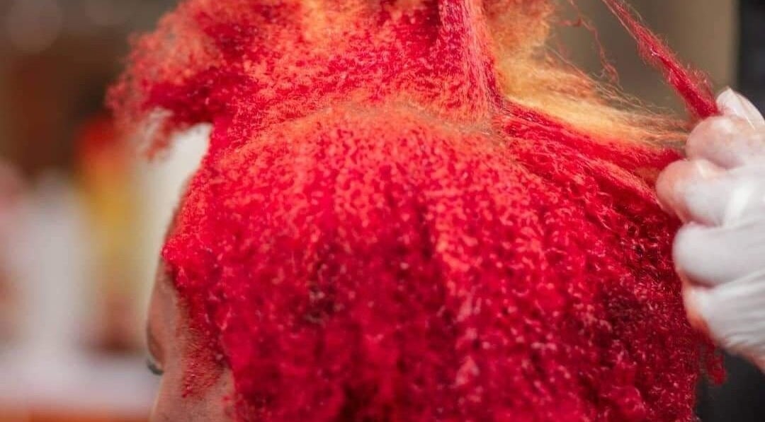 Hair coloring in progress at Georgekutz Hair Studio, Seeb, Muscat Governorate, OM. Vibrant red shades being applied.