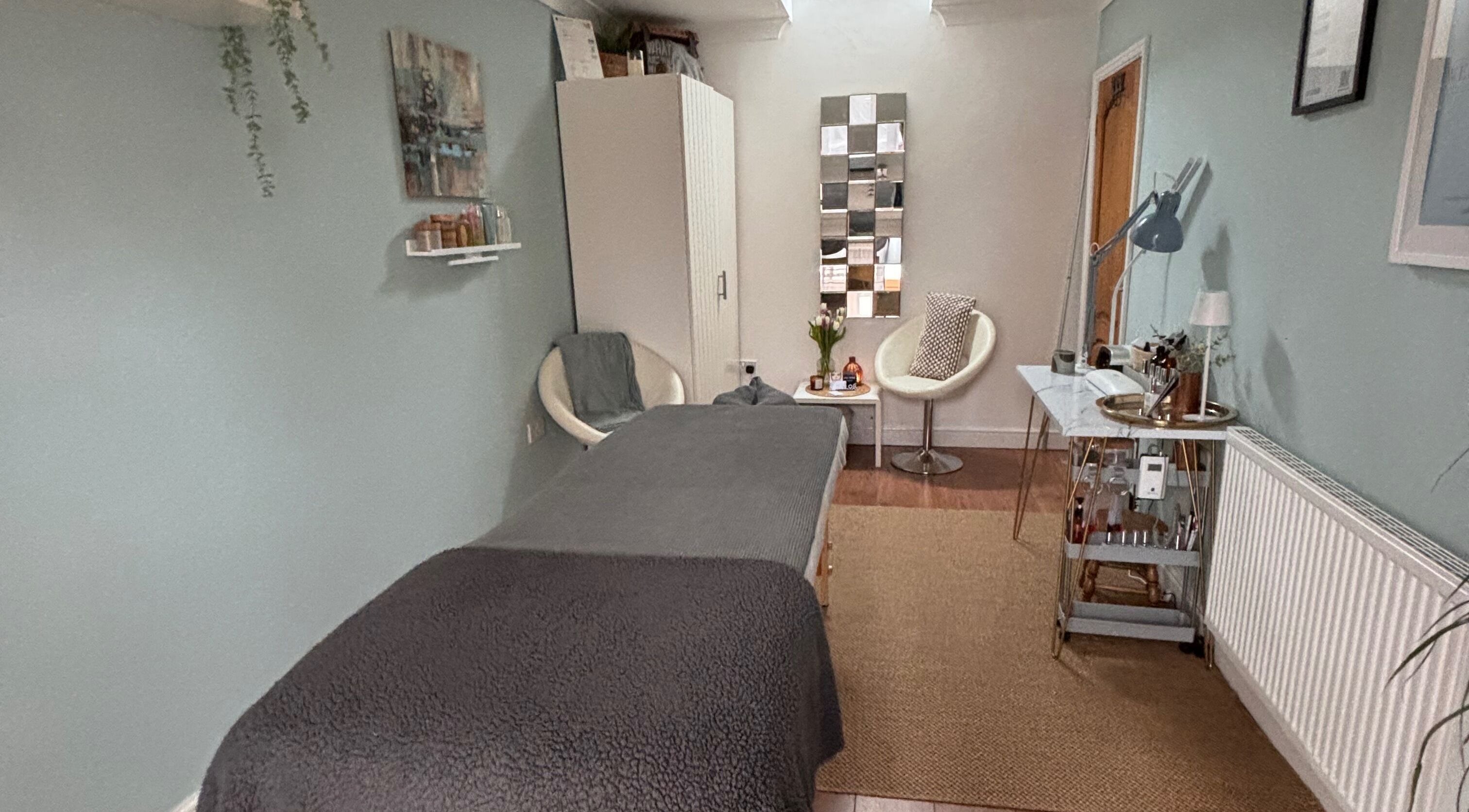 Cozy treatment room at Wellness Beauty - Quorn, Quorn, England, GB, featuring a massage table and modern decor.