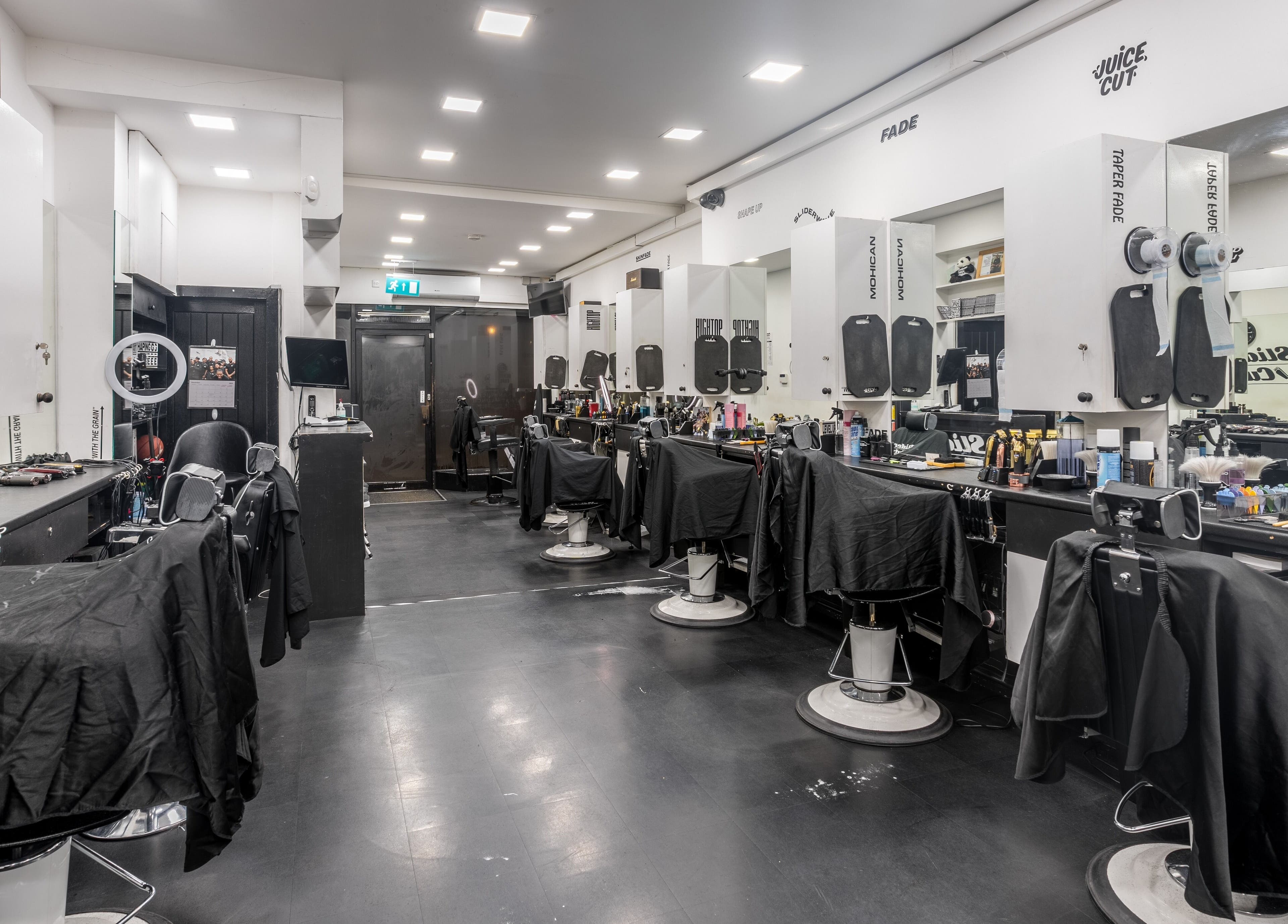 Interior of SliderCuts, a modern barbershop in London, England, GB with sleek chairs and stylish decor.