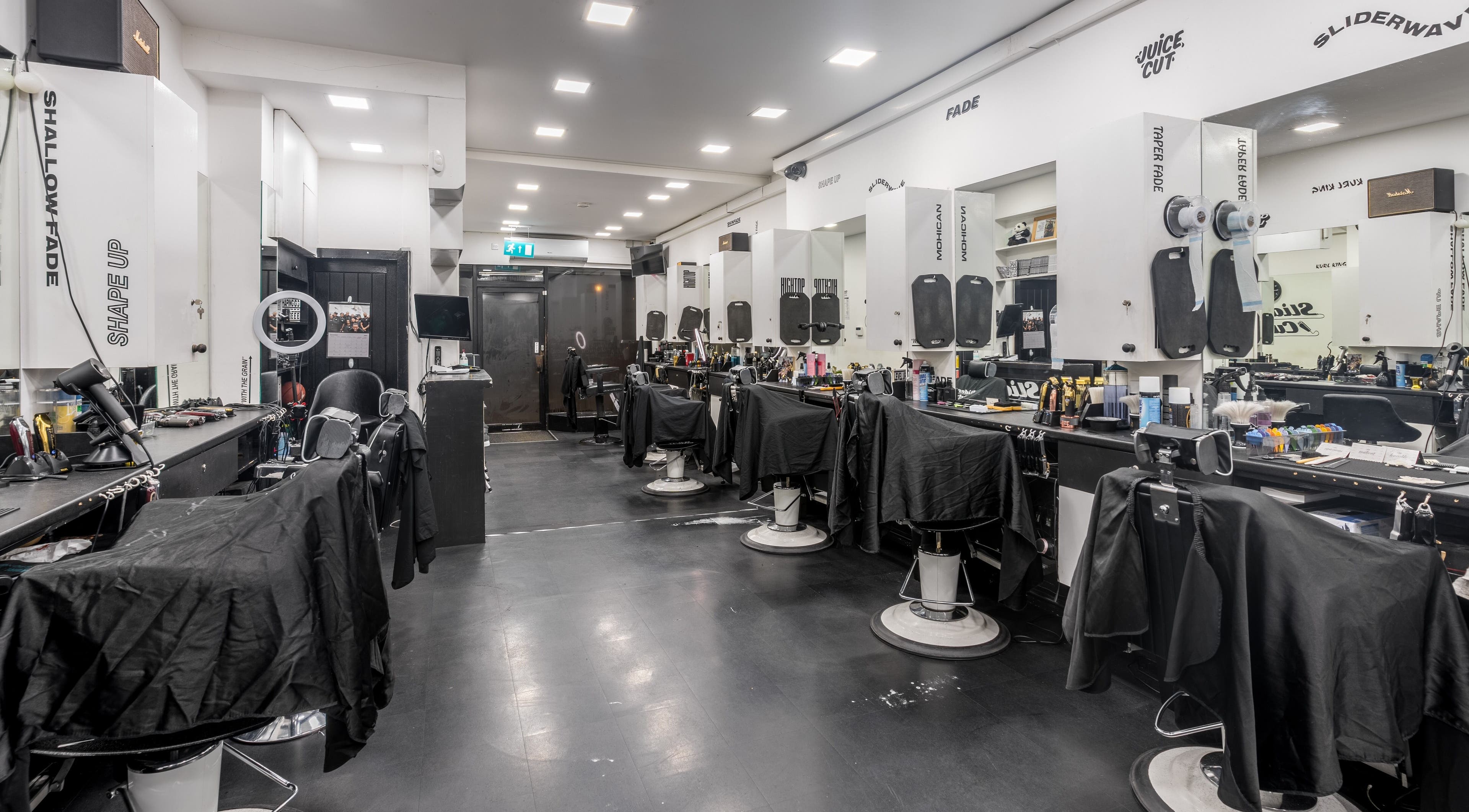 Interior of SliderCuts, a modern barbershop in London, England, GB with sleek chairs and stylish decor.