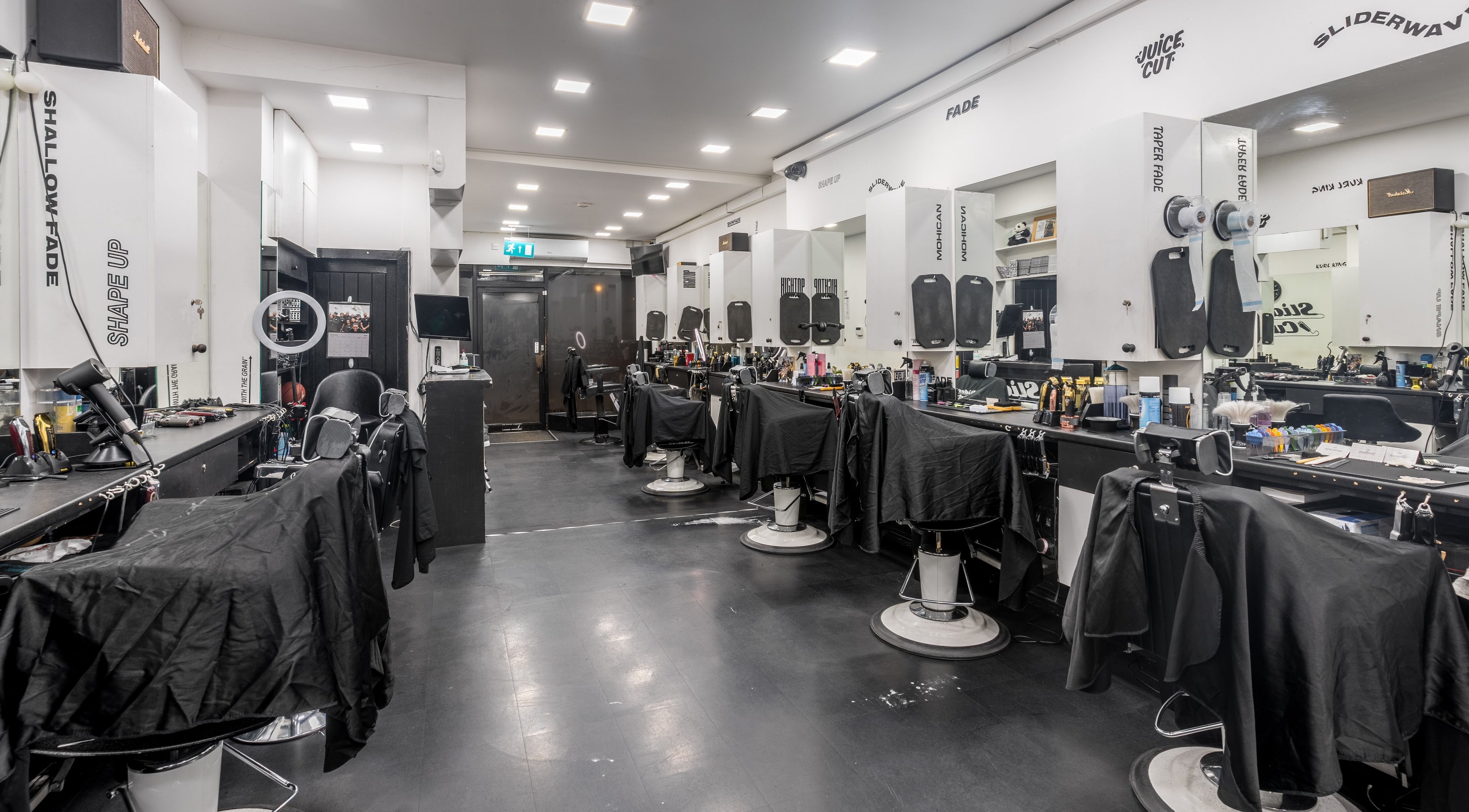 Interior of SliderCuts, a modern barbershop in London, England, GB with sleek chairs and stylish decor.