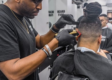 Barber at SliderCuts - Black Eats Fest shaping a client's hair, London, England, GB.