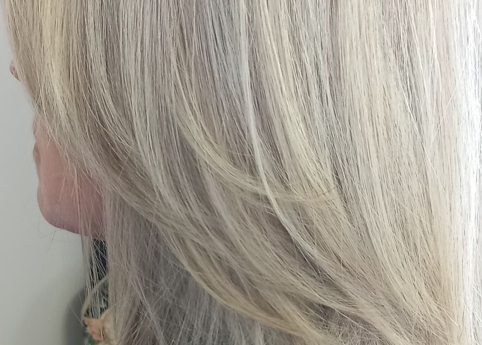 Elegant silver-blonde hair styled at Purple Hair, Sandton, Gauteng, ZA. Smooth layers cascade beautifully.