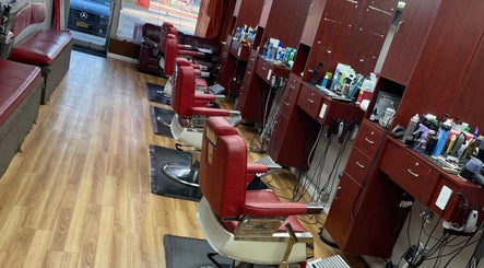 Interior of Another Level Barbershop in Baldwin, New York, US, featuring red barber chairs and wooden cabinets.