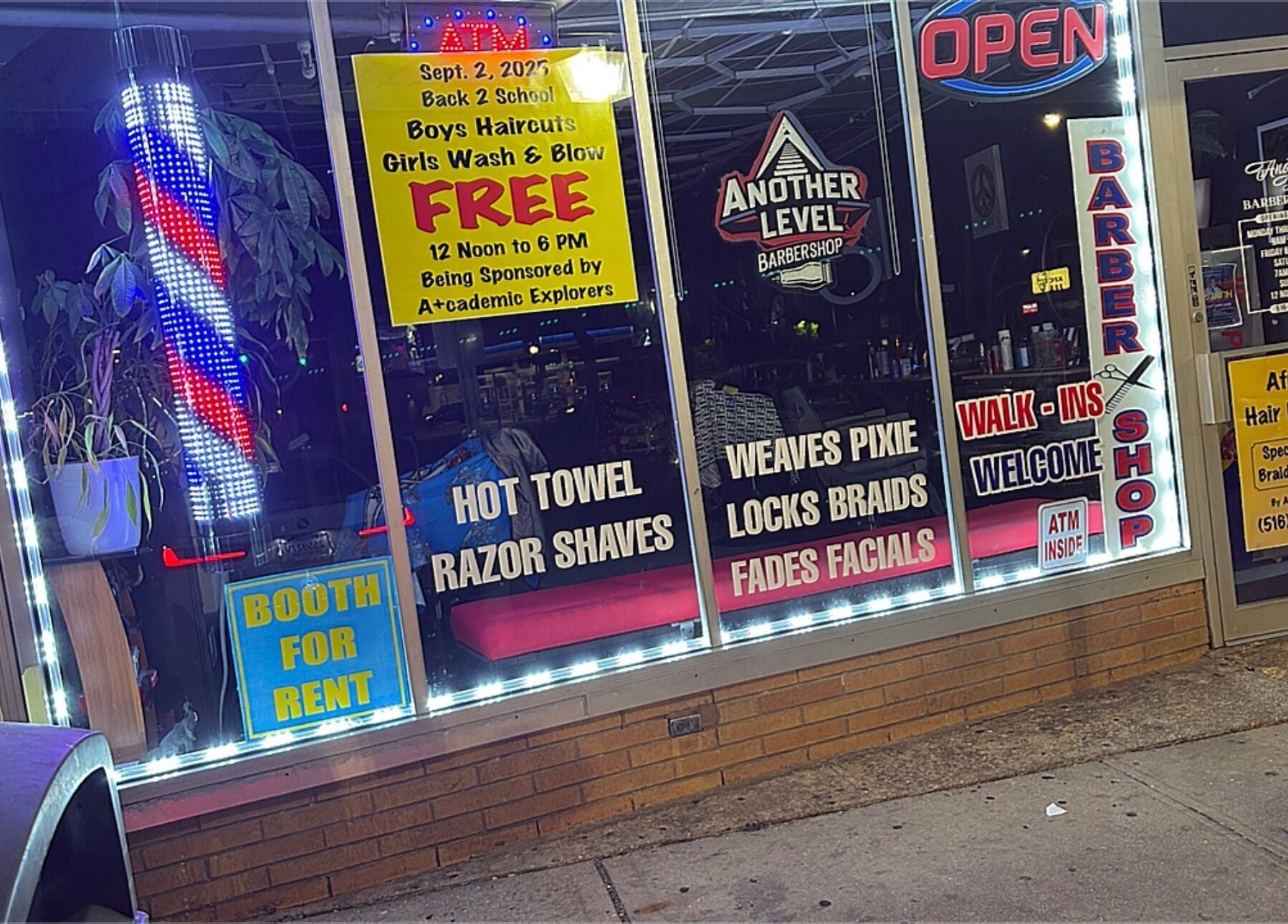 Colorful storefront of Another Level Barbershop in Baldwin, New York, US featuring services and promotions.