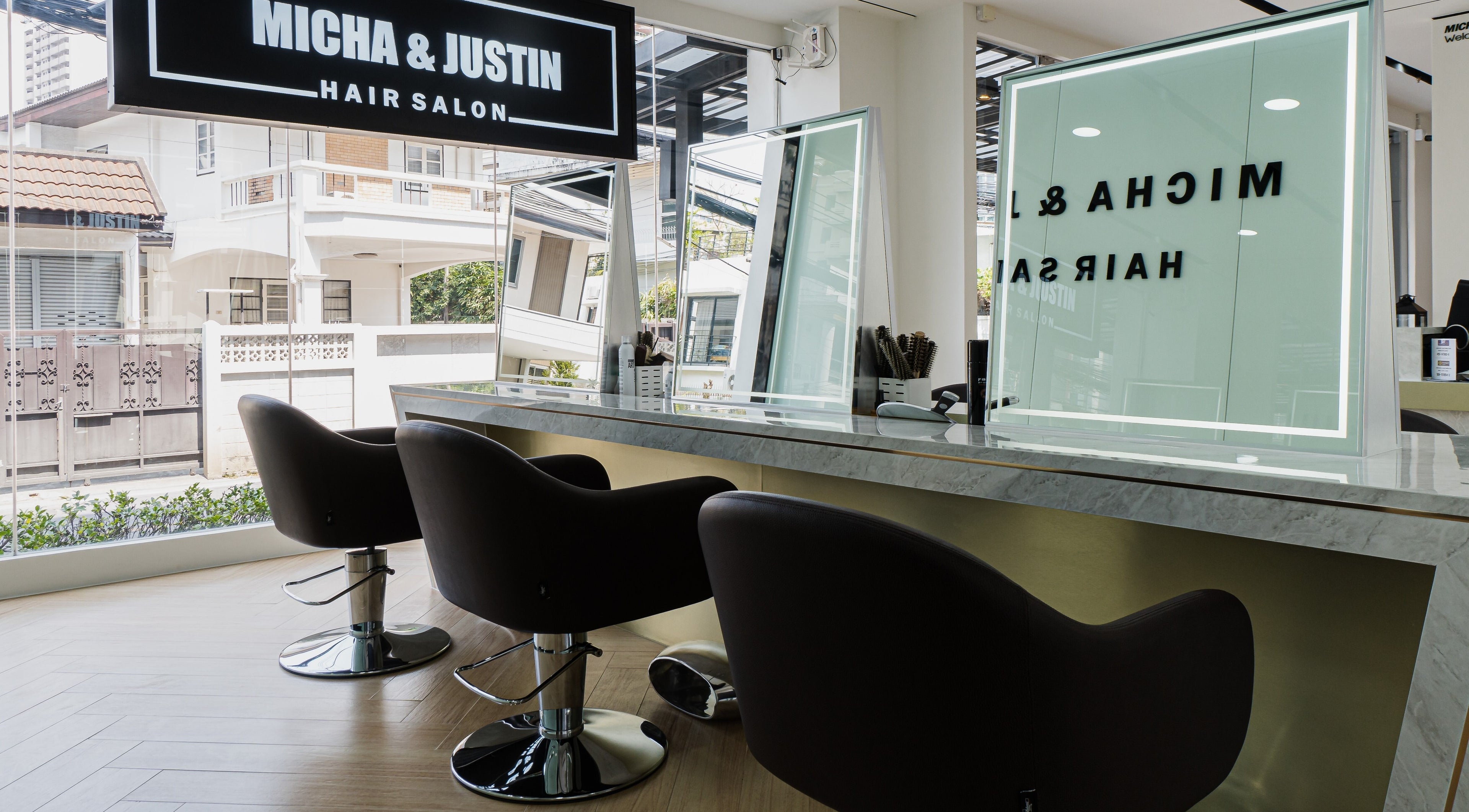 Modern interior of Micha & Justin Hair Salon in Bangkok, Bangkok, TH featuring stylish chairs and mirrors.