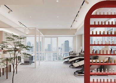 Modern spa interior at Nica Beauty, Hong Kong Island, featuring plush chairs and city views through large windows.