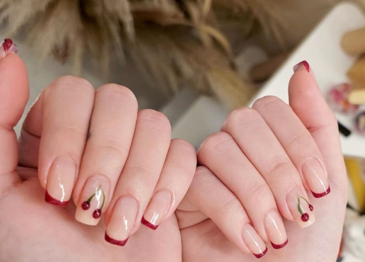 Elegant red-tipped nails with cherry design at Nica Beauty, Hong Kong Island, Hong Kong Island, HK.