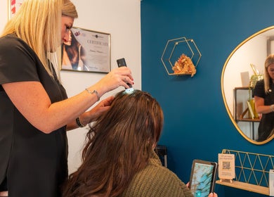 Aura10 stylist performing a hair health check in Long Hanborough, GB, with modern tools and a chic interior.