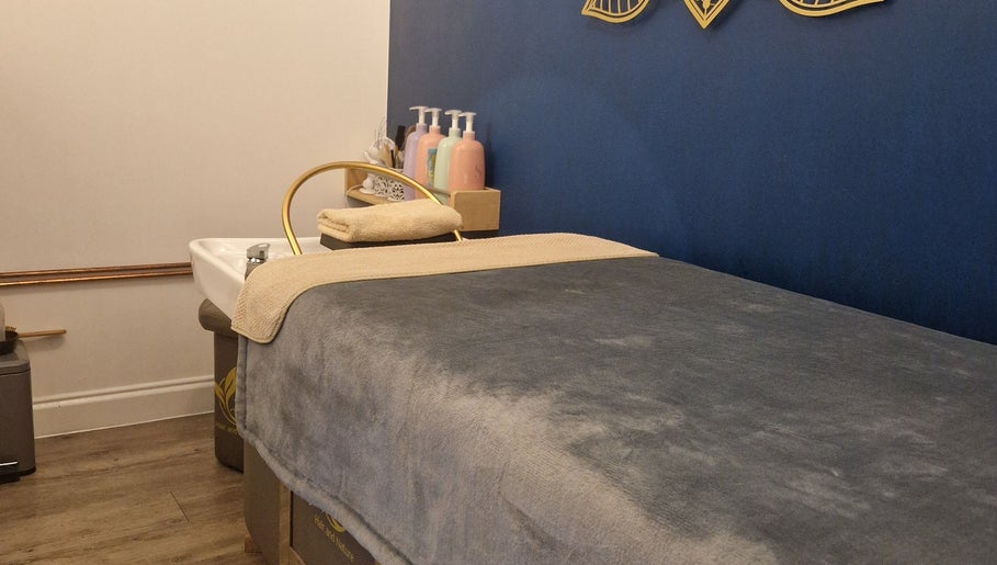 Tranquil spa room at Aura10, Long Hanborough, GB features a plush massage bed and calming decor.