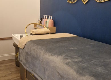 Tranquil spa room at Aura10, Long Hanborough, GB features a plush massage bed and calming decor.