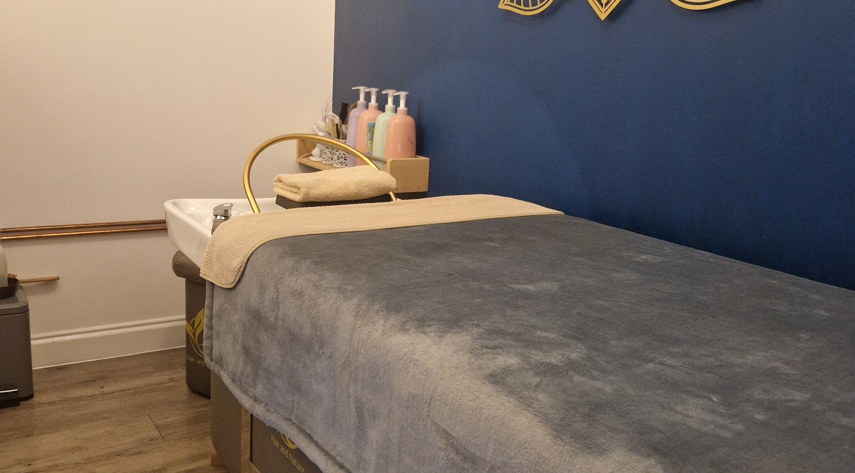 Tranquil spa room at Aura10, Long Hanborough, GB features a plush massage bed and calming decor.