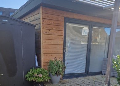 Charming garden view at Aura10 in Long Hanborough, GB, featuring a wooden cabin and lush greenery.