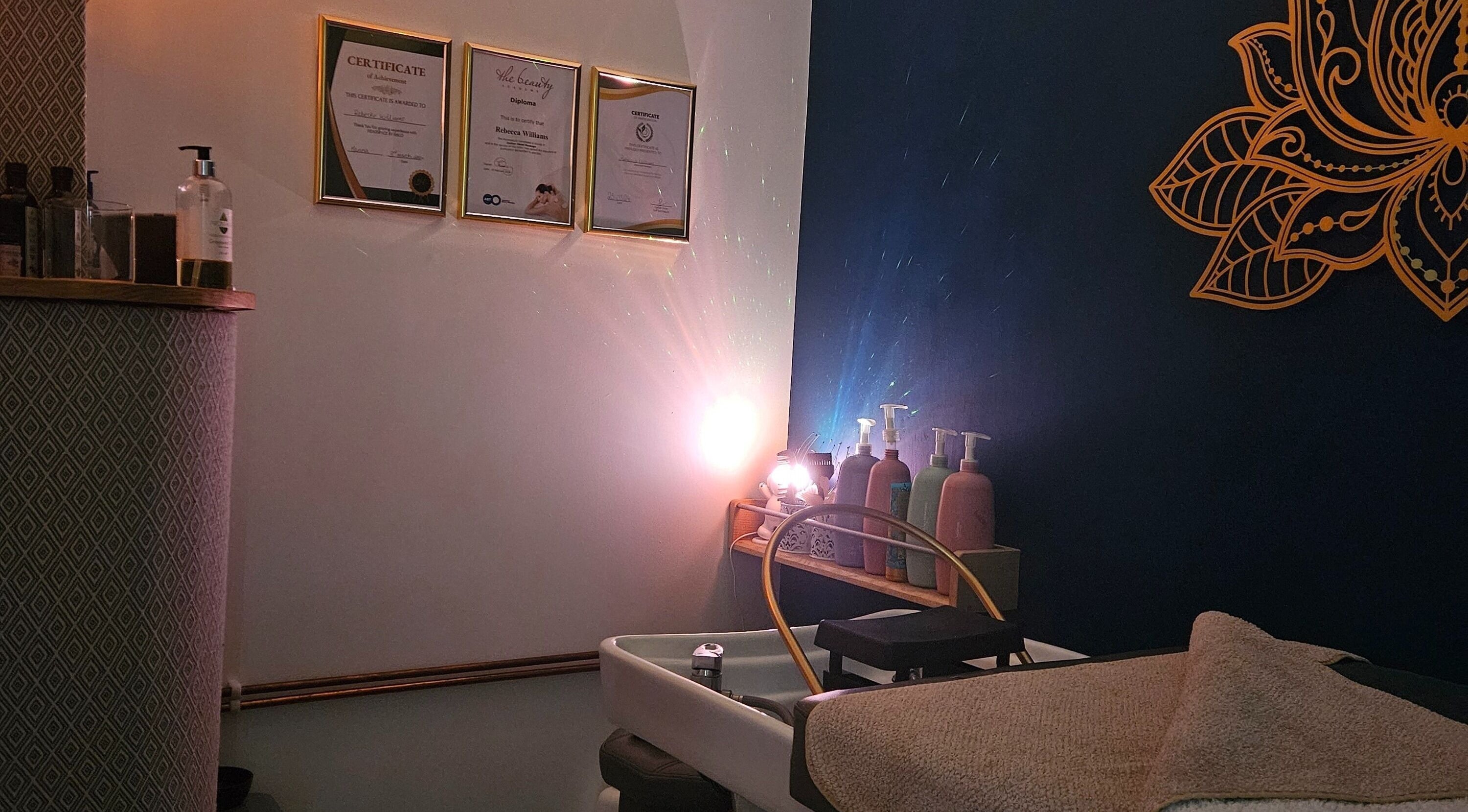 Calming treatment space at Aura10 in Long Hanborough, GB, featuring soothing lighting and certificates.