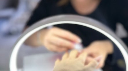 Nail artist at JenLee Beauty in Pretoria, Gauteng, ZA, skillfully polishing nails under perfect lighting.